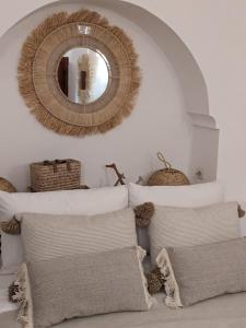 espejo en la pared sobre una cama con almohadas en Riad Le Manzil Beldi, en Marrakech