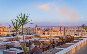 a patio with tables and chairs on a roof at Brown JLM Mamilla, a member of Brown Hotels in Jerusalem