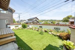 a backyard with a yard of grass and flowers at 湯庵 完全貸し切り庭付き in Matsue