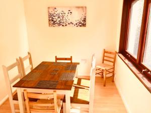 uma sala de jantar com uma mesa de madeira e cadeiras em Invercaul House em Inverness