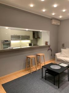 a living room with a couch and a kitchen with stools at Apollo Apartaments in Zagreb +11 photos