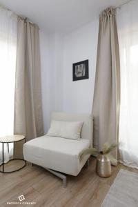 - un lit blanc dans une chambre avec des rideaux dans l'établissement Tranquil Studio Oasis with Chic Decor, à Bucarest