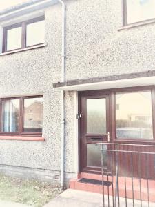 a brick building with a door and windows at Invercaul House in Inverness