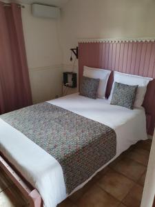 ein Schlafzimmer mit einem großen Bett mit Kissen in der Unterkunft Chambres et Table d'hôte Les Hortensias in La Plaine des Cafres