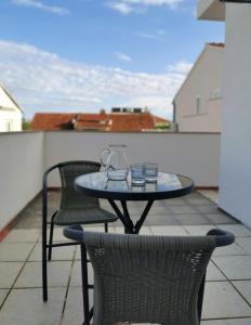 a table and two chairs on a balcony with a table at Apartmani Roza in Vodice