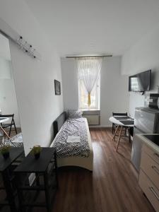 a bedroom with a bed and a table and a window at ApartmentsByMatyrafa-II in Tarnowskie Góry