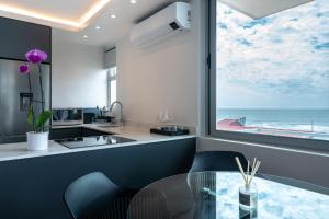 a kitchen with a glass table and a view of the ocean at Perfect beach-side condo in Sea Point, Cape Town with ocean view in Cape Town