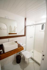 een badkamer met een wastafel, een toilet en een douche bij Hotel Quinta do Porto in Arraial d'Ajuda