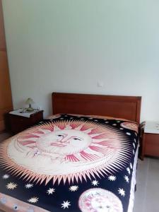 a bed with a blanket with a picture of a santa at Villa Nafsika in Plátonas