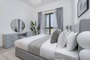 a bedroom with a bed with a mirror and a window at Vogue Jumeirah Living - Near Burj Al Arab & Beach in Dubai +16 photos