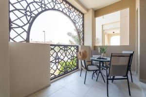 ドバイにあるVogue Jumeirah Living - Near Burj Al Arab & Beachのバルコニー(テーブル、椅子付)、窓が備わります。