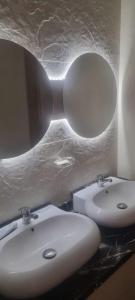 uma casa de banho com 2 lavatórios brancos e um espelho em Royal Cabo Negro Golf em Cabo Negro