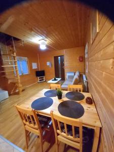 Cette chambre en bois comprend une table, des chaises et un canapé. dans l'établissement Chatka Zuzia, à Polańczyk