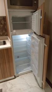 an empty refrigerator with its door open in a kitchen at Al Aseel Hotel in Doha