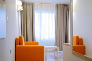 Habitación con 2 sillas de color naranja y ventana en Hotel Garden Nevis - All Inclusive, en Sunny Beach