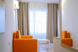 a room with two orange chairs and a window at Hotel Garden Nevis - All Inclusive in Sunny Beach