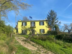 une maison jaune sur le côté d'un chemin de terre dans l'établissement La Villetta Marrucca, à Grosseto