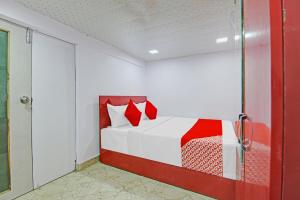 een rood en wit bed in een kamer met een glazen deur bij OYO Flagship Hotel Happiness Inn Near Tdi Mall in New Delhi