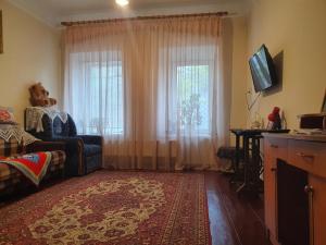 a living room with a couch and a window at Authentic apartment in the centre in Chişinău