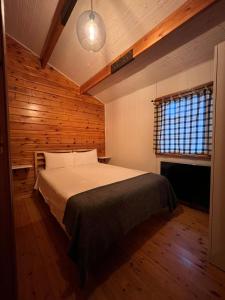 um quarto com uma cama num quarto com paredes de madeira em Villas Vairocana em Santillana del Mar