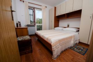 ein Schlafzimmer mit einem großen Bett und einem Fenster in der Unterkunft Apartments Val Mari - Laguna in Rovinj