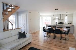 een woonkamer met een witte bank en een tafel bij Le Citadin - Maison neuve moderne & ensoleillée in Québec