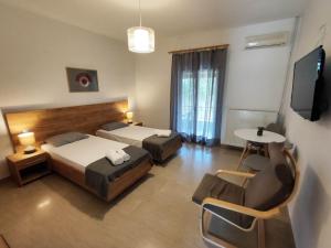 a hotel room with two beds and a table at Tony's Garden House in Lefkimmi