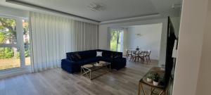 Una sala de estar con un sofá azul y una mesa. en Apartment Zamkowa Park, en Węgorzewo