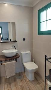 a bathroom with a white toilet and a sink at Casa Julia in Tías