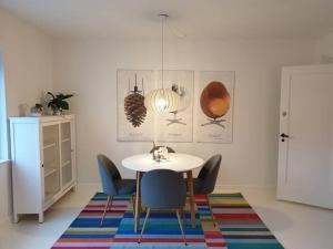 een eetkamer met een tafel en stoelen op een tapijt bij Charmerende lejlighed i Viby in Viby