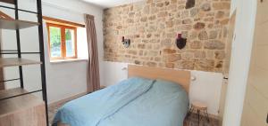 a bedroom with a bed and a brick wall at Mas Le Corbery in Largentière