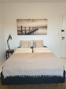 a bedroom with a bed with a picture on the wall at Charmerende lejlighed i Viby in Viby