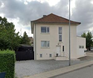 a white house sitting on the side of a street at Charmerende lejlighed i Viby in Viby