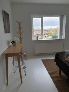 een woonkamer met een tafel en een raam bij Charmerende lejlighed i Viby in Viby