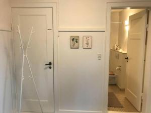 a white door in a room with a bathroom at Charmerende lejlighed i Viby in Viby
