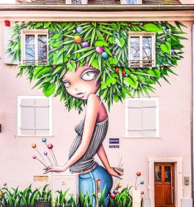 una pintura de una chica parada frente a un edificio en Duplex atypique au cœur de Mulhouse, en Mulhouse
