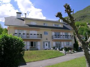 une grande maison blanche avec une colline en arrière-plan dans l'établissement Villa Casa-Bosta, à Ayzac-Ost