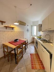 una cucina con tavolo, lavandino e bancone di Casagioia a Cefalù