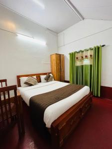 a bedroom with a large bed with green curtains at Coorg Daffodil Guesthouse in Madikeri