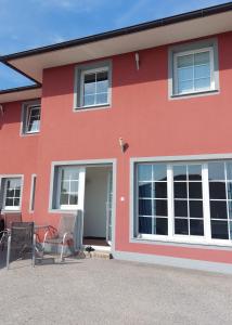 a red house with two chairs in front of it at Apartma Sandi in Šentilj