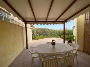 - une table et des chaises blanches sur la terrasse dans l'établissement La "Piccola della Gioia", à Birgi Vecchi