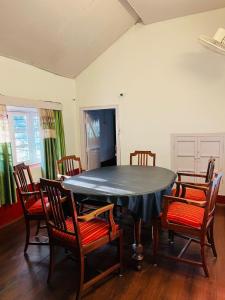 a dining room with a black table and chairs at Coorg Daffodil Guesthouse in Madikeri