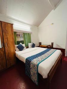ein Schlafzimmer mit einem großen Bett in einem Zimmer in der Unterkunft Coorg Daffodil Guesthouse in Madikeri