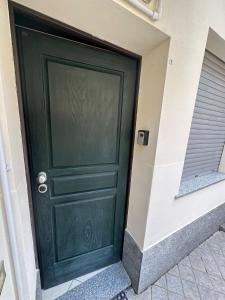 una porta verde sul lato di un edificio di Appartamento per 4 persone in centro Alba ad Alba