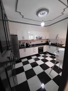 a kitchen with a black and white checkered floor at Al-marsa2 in Al Hoceïma