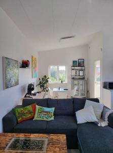 sala de estar con sofá azul y mesa en Solrig og moderne villalejlighed tæt på midtbyen 