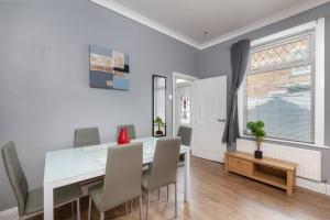 a white dining room with a white table and chairs at Large Parade Coastal House in Hartlepool