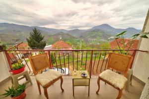 a balcony with two chairs and a table with a view at Smestaj Rakovic in Pribojska Banja