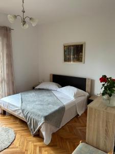 a bedroom with a bed and a plant on a table at Guesthouse Klečak in Cavtat