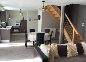 uma sala de estar com uma mesa e uma cozinha com uma escada em Espace Acu-Nature em Saint-Évarzec